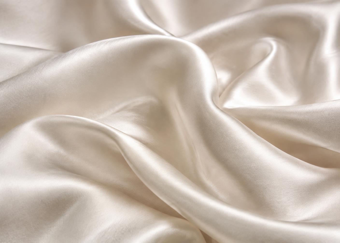 Close detail of champagne mulberry silk draped in soft folds